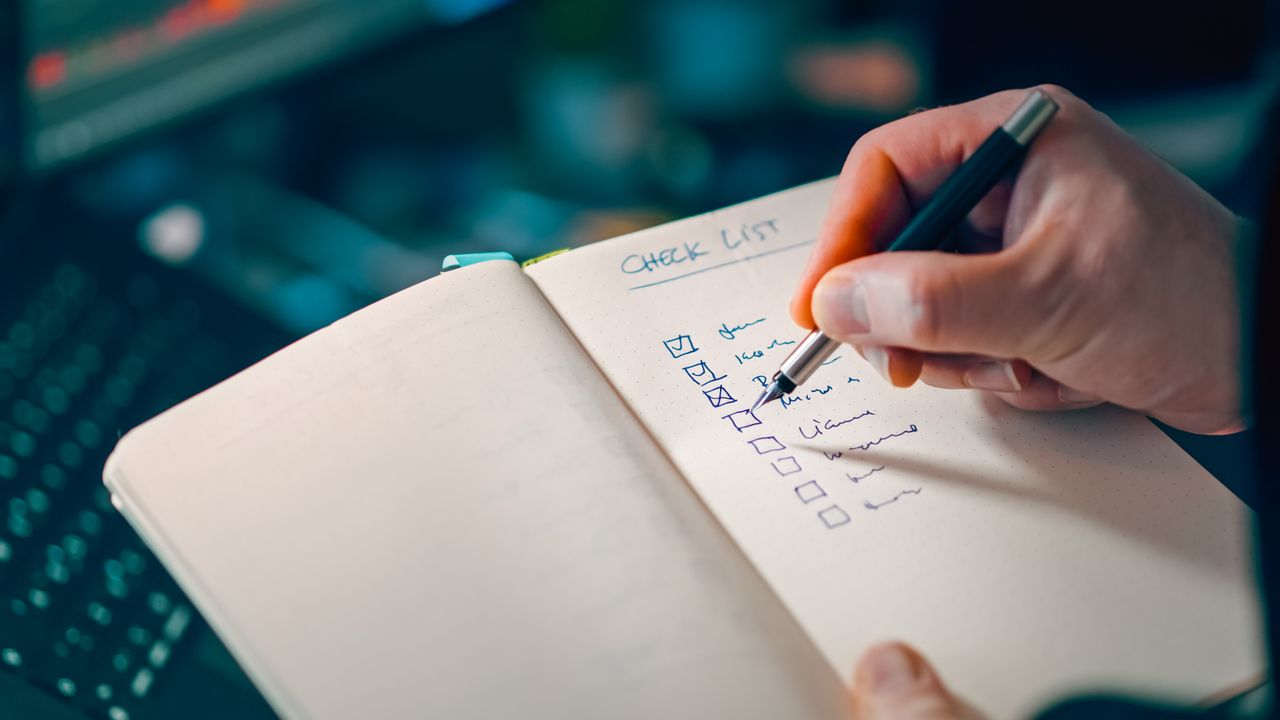 Hand writing a checklist in a notebook — B2B landing page pre-launch review
