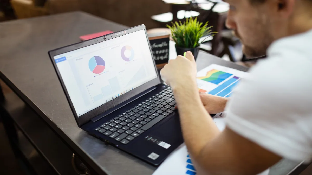 Analyst comparing free and paid Crazy Egg alternatives on a laptop with charts